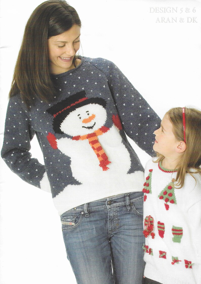 Pu&ograve; includere: Due persone indossano maglioni di lana a tema natalizio. L'adulto indossa un maglione blu con un disegno di pupazzo di neve bianco. Il bambino indossa un maglione bianco con un disegno di albero di Natale verde. DESIGN 5 & 6 ARAN & DK