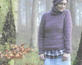 May include: A purple knitted sweater with a turtleneck and a textured pattern. The sweater is worn over a plaid shirt and a denim skirt. The person is wearing a gray knit hat.