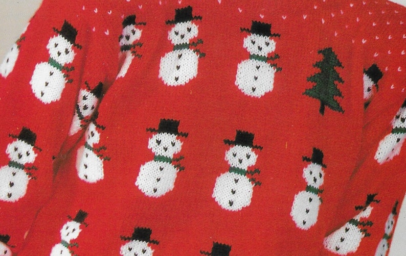 May include: Red knitted sweater with a white snowman pattern. The sweater is covered in snowmen with black hats and green scarves.