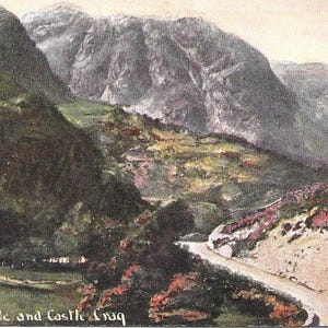 May include: A vintage postcard showing a picturesque view of Borrowdale and Castle Crag in the Lake District, England. The image features a winding road ascending a mountainside, with verdant foliage and rugged cliffs in the distance.