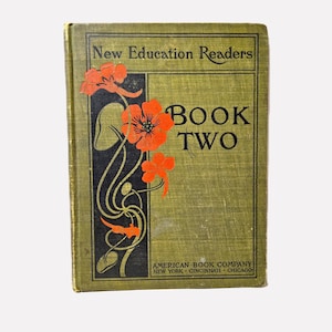 May include: Vintage "New Education Readers" Book Two. The cover is olive green with orange floral accents and black decorative lines. The book's title is in large, bold letters. The publisher's name and city locations are printed at the bottom.