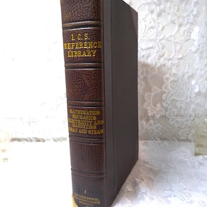 May include: A vintage hardcover book with a brown leather spine and dark brown cover. The spine features gold lettering that reads "I.C.S. REFERENCE LIBRARY" and "MATHEMATICS MECHANICS ELECTRICITY AND MAGNETISM HEAT AND STEAM". The book is a classic educational resource.