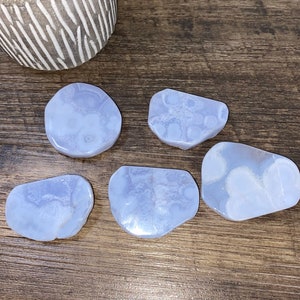 May include: Five blue lace agate slices with white patterns. The slices are smooth and polished.