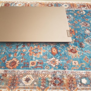 Puede incluir: Un portátil rectangular cerrado de color bronce metálico con un acabado liso. El dispositivo cuenta con una pequeña placa rectangular con el logotipo de la marca Lenovo en el lado derecho de la tapa, mostrando el texto Lenovo en letras blancas.