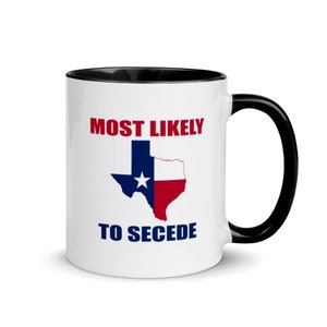 Puede incluir: Taza de café blanca con borde y asa negros. La taza tiene un gráfico de la bandera de Texas con el texto "MOST LIKELY TO SECEDE" impreso en ella.