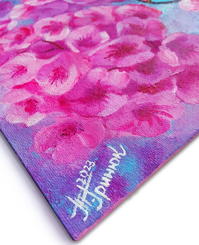 Puede incluir: Un primer plano de una pintura de flores rosas sobre un fondo morado. La pintura est&aacute; firmada "JF 2023" y "remarkable" en pintura blanca.