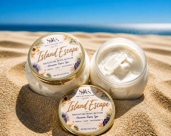 May include: Two round clear plastic jars of white body butter with gold lids. The labels read Island Escape Signature Body Butter Hawaiian Tropics Type, Net Wt. 8 oz (227 g). One jar is open, and one lid is placed in front on the sand.