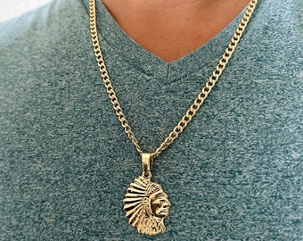 May include: A gold chain necklace with a gold pendant featuring a profile of a Native American chief wearing a headdress.