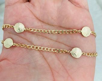 May include: Two gold chain bracelets with small round medallions. Each medallion has a raised image of a religious figure.