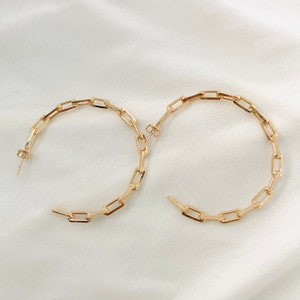 May include: Gold hoop earrings with a chain link design.