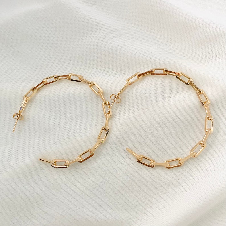 May include: Gold hoop earrings with a chain link design.