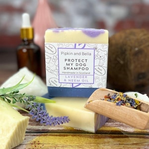 May include: A bar of lavender and neem oil dog shampoo with a white label that reads "Protect My Dog Shampoo" and "Pipkin and Bella". The label also includes the text "Handmade in Scotland" and "Smell Wonderful".