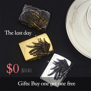 May include: Three metal lighters with wing designs. One is black with gold accents, another is gold, and the third is silver with black accents. The text "Amazon" is visible on each lighter. The phrase "The last day" is also visible.