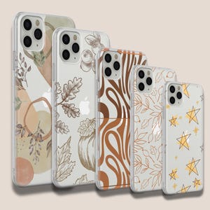 Op de afbeelding: Set van vier transparante telefoonhoesjes met verschillende ontwerpen. De hoesjes hebben abstracte patronen in bruin, wit en beige. De ontwerpen omvatten een pompoen, bladeren, sterren en swirls.