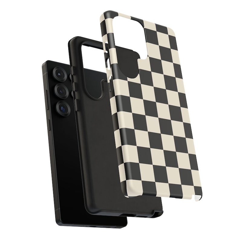 May include: A black smartphone with a black case and a separate phone case with a black and cream checkerboard pattern. The phone has three camera lenses. The phone case is slightly separated from the phone.