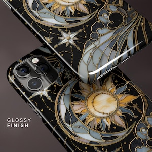 May include: Black phone case with a celestial design featuring a sun, moon, and stars in a stained glass style. The case has a glossy finish and gold accents. The text "GLOSSY FINISH" is visible.