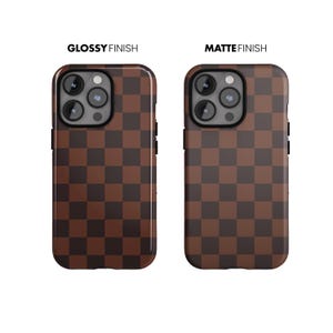 May include: Two phone cases with a brown and dark brown checkered pattern. One case has a glossy finish, and the other has a matte finish. The text "GLOSSY FINISH" and "MATTE FINISH" are above each case.