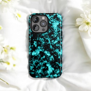 May include: A smartphone case with a teal and black marble design. The case has a glossy finish and a black border. The phone case is lying on a white surface with white flowers.