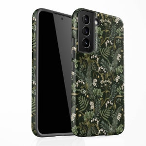 May include: A black phone case with a floral pattern featuring green leaves, white flowers, and gold accents. The case has a cutout for the camera lens.