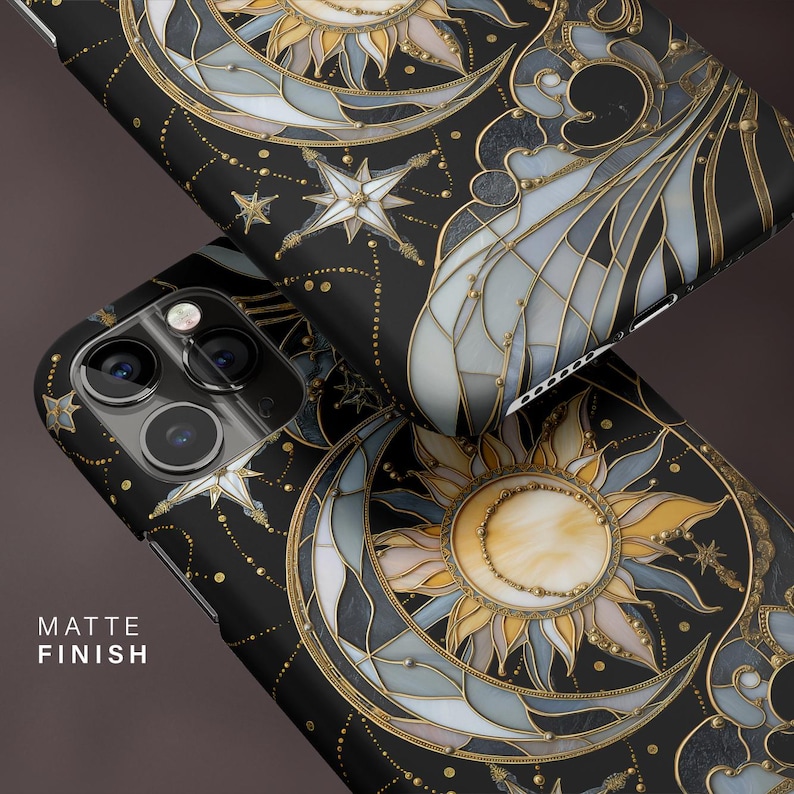 Pu&ograve; includere: Custodie per telefono nere con un design celeste raffigurante un sole, una luna e stelle in oro, bianco e grigio. Le custodie hanno una finitura opaca e un motivo dettagliato in stile vetrata. Il testo "MATTE FINISH" &egrave; visibile.