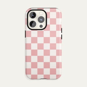 May include: A pink and white checkered phone case for an iPhone 13 Pro Max.