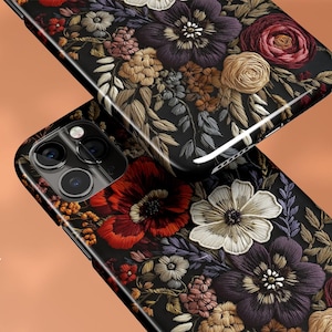 K&ouml;nnte beinhalten: Schwarze Handyh&uuml;llen mit gl&auml;nzendem Finish, verziert mit detaillierter floraler Stickerei in Rot-, Lila-, Creme- und Goldt&ouml;nen. Das Design zeigt verschiedene Blumenarten und Bl&auml;tter.
