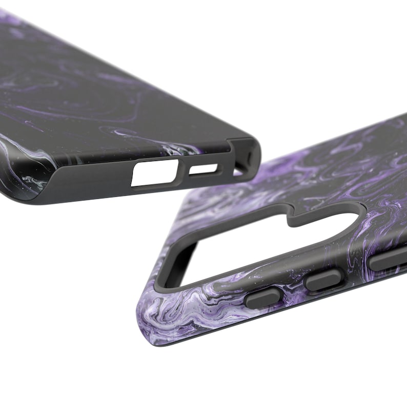 May include: Two black phone cases with a purple and white marbled design. The cases have a sleek, modern design with cutouts for the camera and buttons. The cases are made of a durable material and offer protection for the phone.
