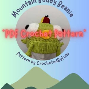 May include: A green crocheted beanie with large white and black eyes, a yellow patch, and a small red and yellow hat. The text "Mountain Buddy Beanie" and "PDF Crochet Pattern" are displayed on the image. The pattern is by CrochetedByLuna.