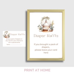 May include: A framed baby shower sign with the text "Diaper Raffle." The sign features a watercolor illustration of a baby crib and plants. A smaller card with the same design is also visible.