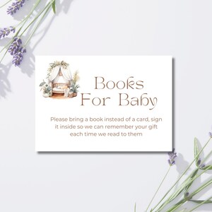 Könnte beinhalten: Eine weiße Karte mit dem Text "Books For Baby" in brauner Schrift, mit einer Aquarellillustration einer Babywiege. Die Karte enthält auch eine Bitte, ein Buch anstelle einer Karte mitzubringen. Lavendelzweige umrahmen die Karte.