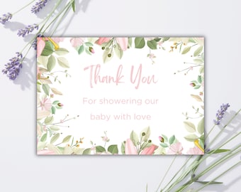 May include: A baby shower thank you card with a floral design. The card features the words "Thank You" in pink script, along with the message "For showering our baby with love." The card is surrounded by pink and green floral elements.