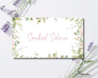 May include: A white rectangular card with the text "Smoked Salmon" in pink script, framed by a floral border of green leaves and pink flowers. Lavender sprigs are placed on the top and bottom.