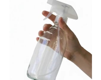 Botella de vidrio transparente con tapa pulverizadora.