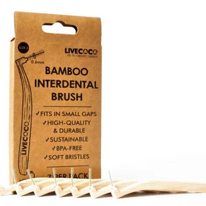 Puede incluir: Un paquete de siete cepillos interdentales de bambú con cerdas suaves. El embalaje es de cartón marrón con el texto "LIVECOCO BAMBOO INTERDENTAL BRUSH" y una lista de características: "FITS IN SMALL GAPS, HIGH-QUALITY & DURABLE, SUSTAINABLE, BPA-FREE, SOFT BRISTLES".