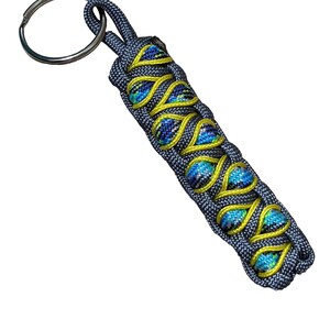 A keychain with a metal ring and a braided pattern in blue and yellow colors.