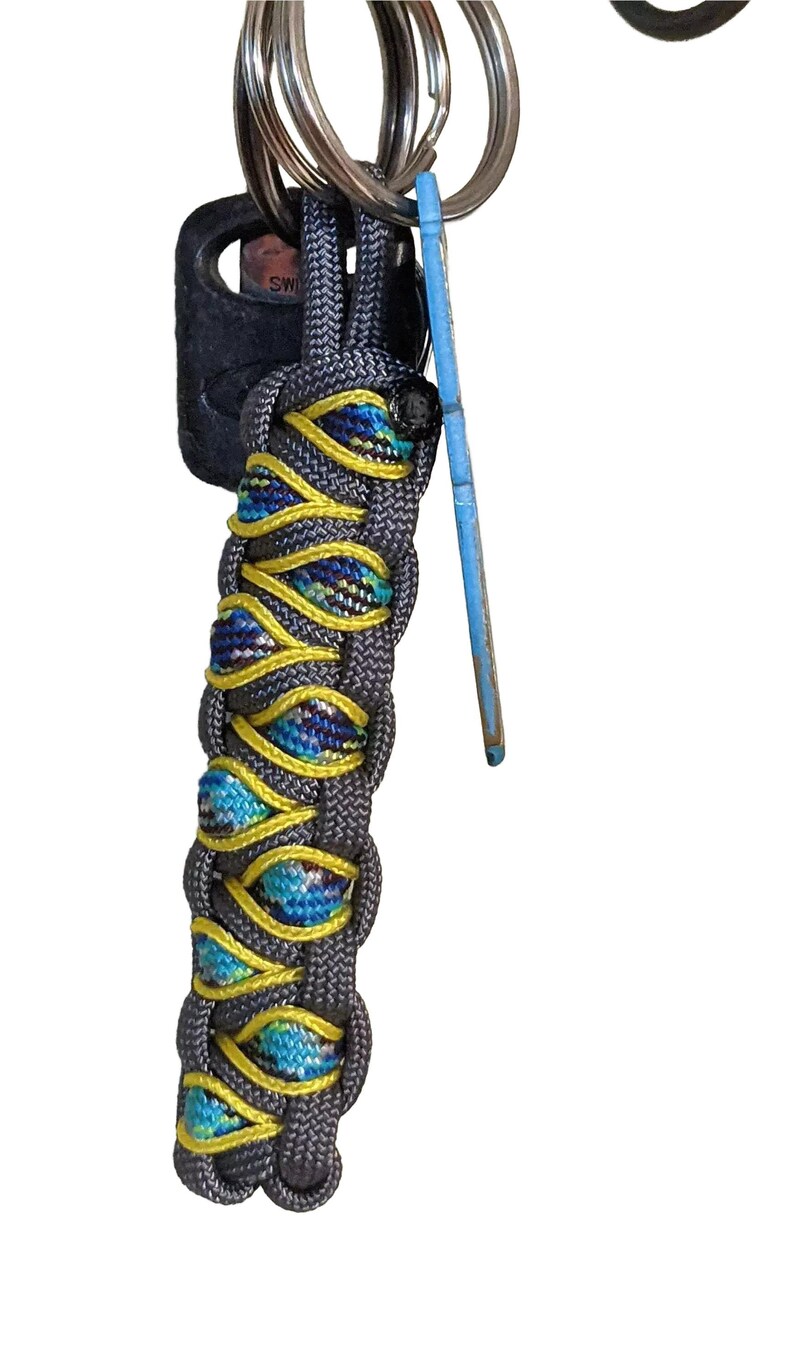 A multi-colored braided keychain with a blue and yellow pattern, hanging from a keyring.