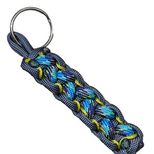A keychain made of blue and yellow braided cord, with a metal ring attached.