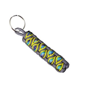 A gray and yellow braided keychain with a metal ring attached.