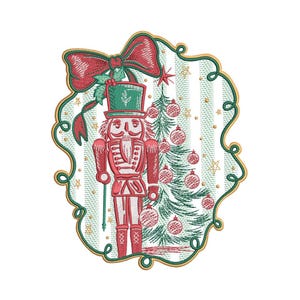 May include: Embroidered Christmas design featuring a red and white nutcracker soldier with a green top hat, standing next to a decorated Christmas tree. The design includes a red bow and is framed with a gold border on a striped background.