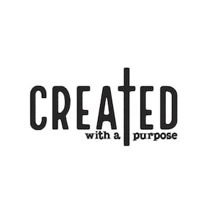 May include: Black and white graphic design with the word "CREATED" and a cross in the middle. The text "with a purpose" is below the cross.