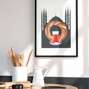 May include: A framed print with a black and white illustration of a Turkish tea glass and a simit (Turkish bagel) in front of a silhouette of a mosque.