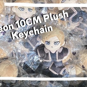 May include: A selection of Leon 10cm plush keychains. Each plush toy depicts a character with blonde hair, blue eyes, and a dark outfit. The keychains are packaged in clear plastic. Text on the image reads "Leon 10CM Plush Keychain."