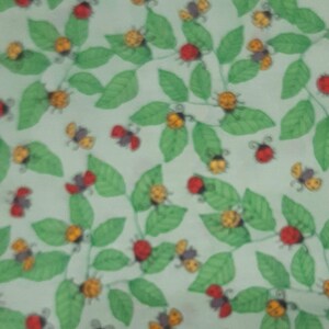 May include: A green fabric with a repeating pattern of red ladybirds and yellow bumblebees on green leaves.