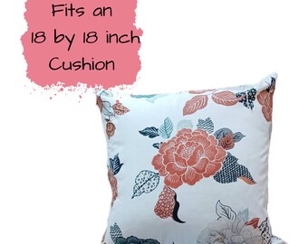 May include: A white cushion cover with a floral pattern in shades of orange, blue, and grey. It fits an 18 by 18 inch cushion.