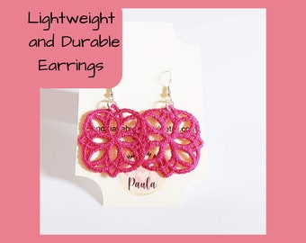 Puede incluir: Pendientes de crochet rosa con ganchos plateados. Los pendientes se muestran en una tarjeta blanca con el texto "Lightweight and Durable Earrings" y "Paula".