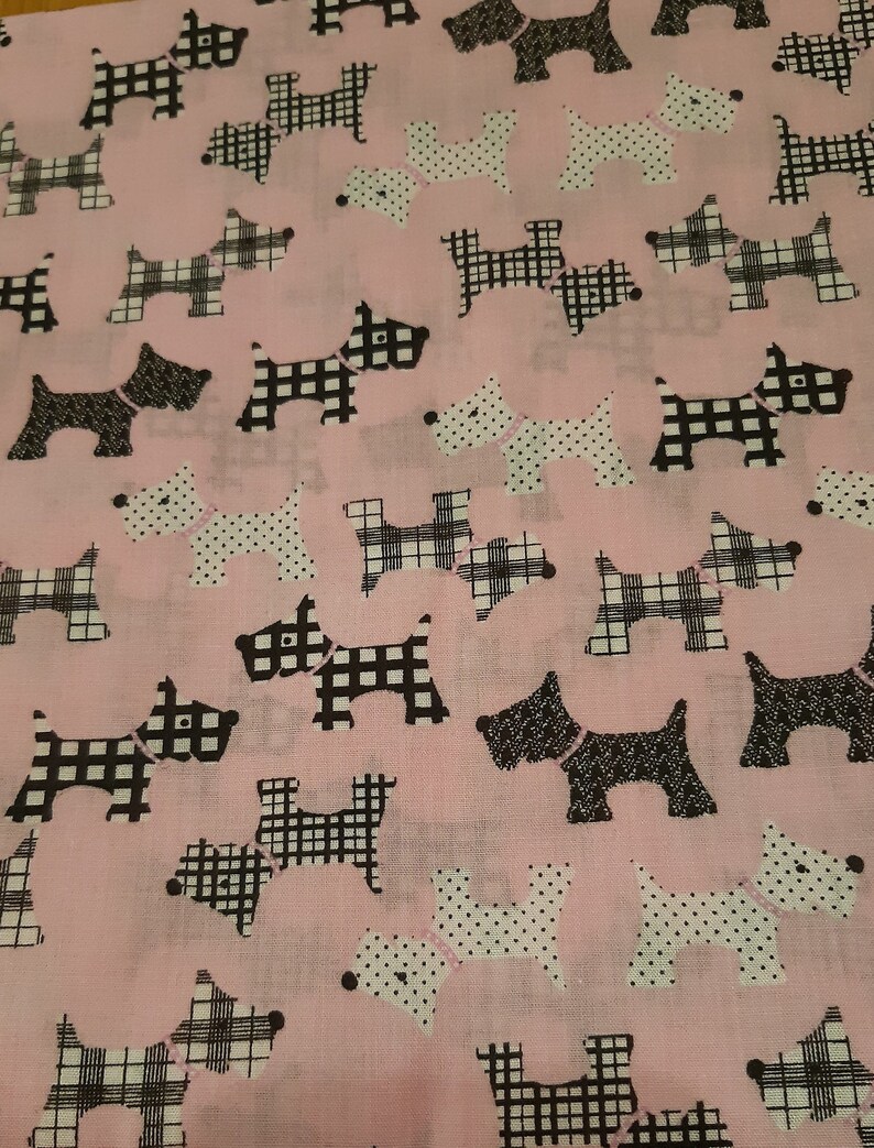 May include: Pink fabric with a repeating pattern of black and white Scottish terrier dogs. Some dogs are wearing a pink collar with white polka dots, while others are wearing a black and white plaid collar.