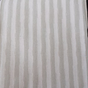 May include: White fabric with thin, grey stripes. The fabric has a woven texture.