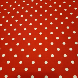 May include: Red fabric with a white polka dot pattern.