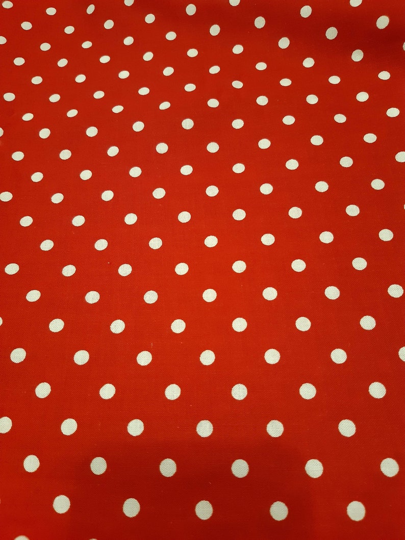 May include: Red fabric with a white polka dot pattern.
