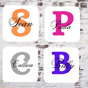May include: Four square white tiles against a brick background. Each tile displays a large, coloured letter and a name in cursive: orange "S" for Sean, pink "P" for Paula, grey "C" for Callum, and purple "B" for Billy.